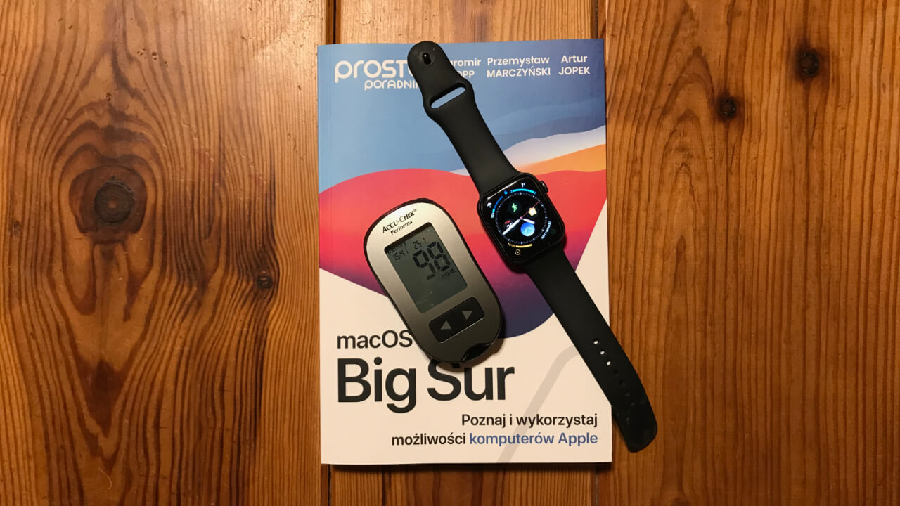 Glukometr i Apple Watch na tle podręcznika do macOS Big Sur